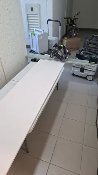 수납장 문짝 달기 — 현관 앞 복도에 펼친 작업대와 레일 톱